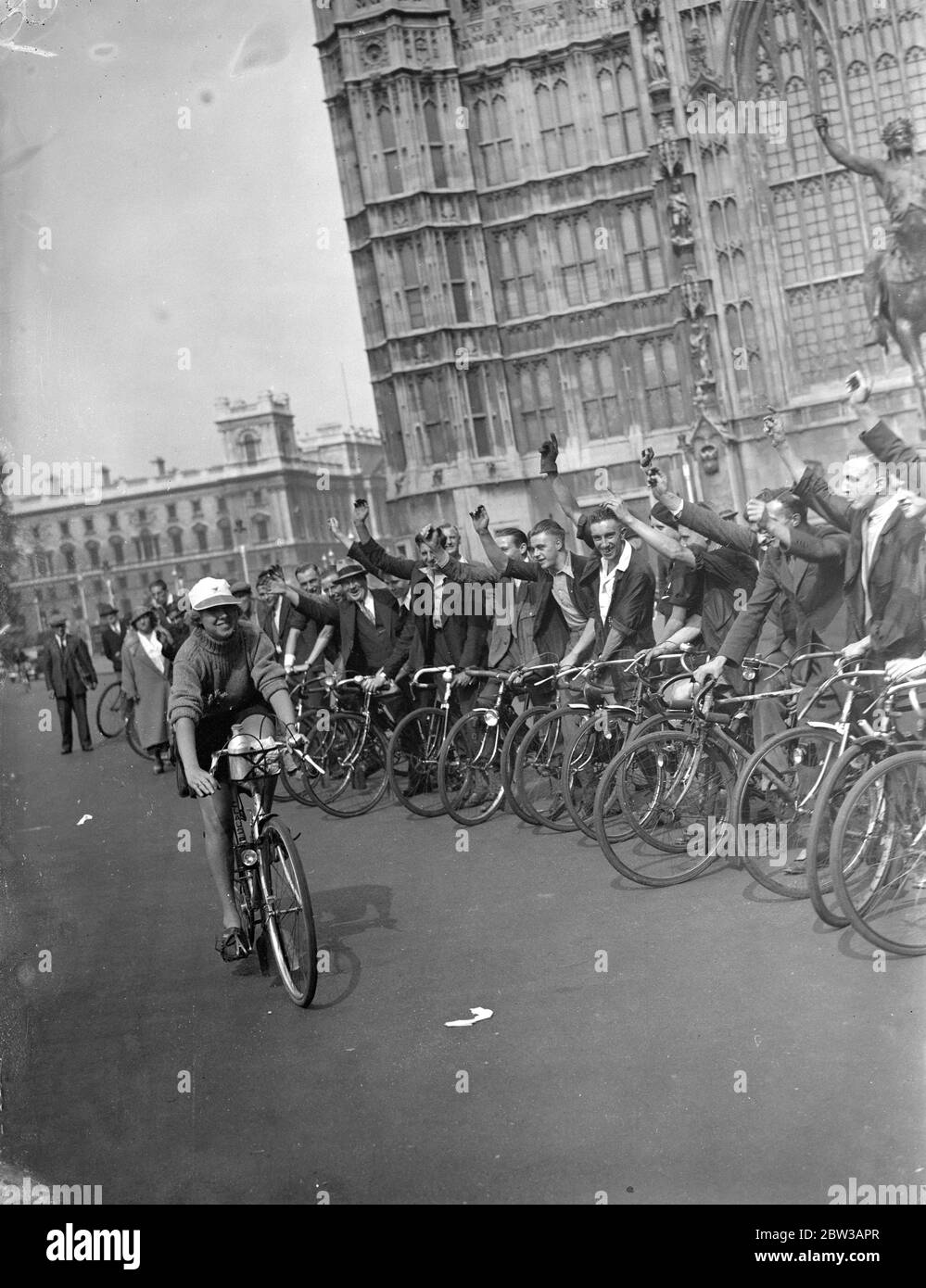 Miss Evelyn Hamilton, die Frauen s Radsportmeisterin, versucht, 1, 000 Meilen in einer Woche zu decken. Foto zeigt Miss Hamilton auf ihrem Fahrrad, das an einer Reihe männlicher Radfahrer vorbeifährt 14. September 1934 Stockfoto