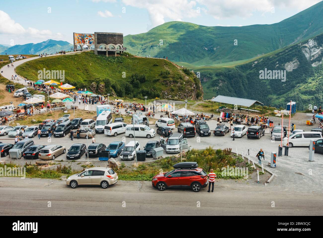 Touristen halten an, um das Russland-Georgien Freundschaftsdenkmal auf einer Autobahn in den Kaukasus-Bergen, Georgien zu besuchen. Erbaut 1983 Stockfoto