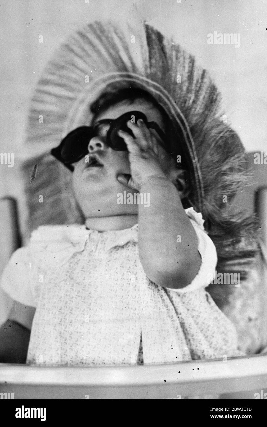 Die Kinnsqualen sehen die Welt durch rosarote Brillen. Yvonne Dionne hebt den Kopf, um zu sehen, ob der Himmel auch seinen Farbton geändert hat. 22. September 1935 Stockfoto