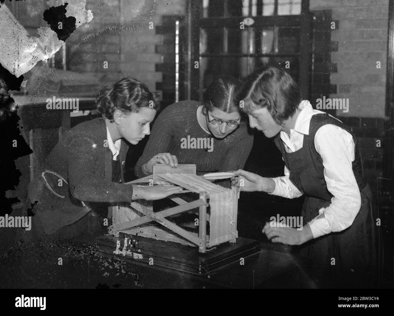 London 's up to date Schule. Mädchen lernen, auf Webstühlen zu weben. Gelehrte weben auf einem Tisch Handwebstuhl . 16. Oktober 1935 Stockfoto