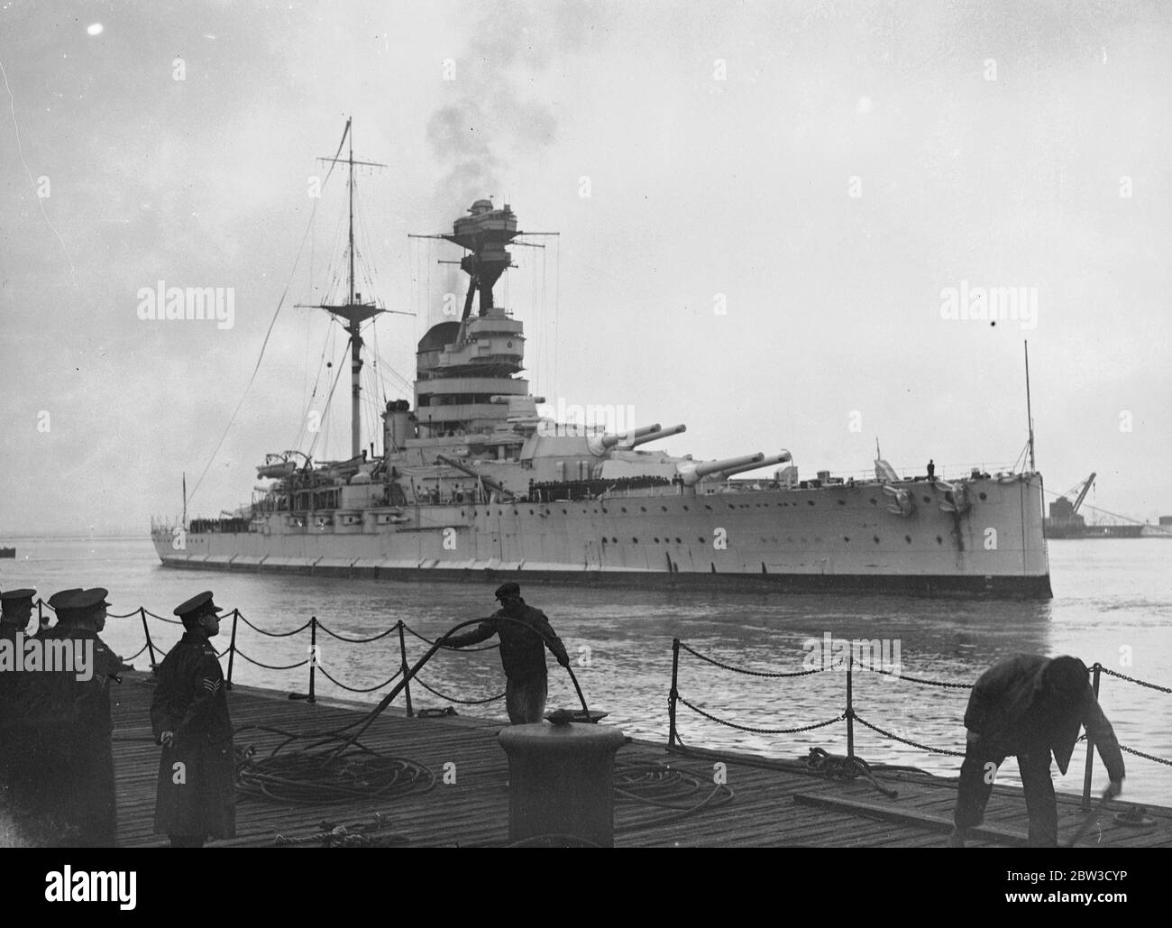 Schlachtschiff Haus aus dem mittelmeer . Segler verbringen weihnachten in England. Die 29 , 150 Tonnen Schlachtschiff HMS Resolution (Wimpel Nummer 09) kam in Porstmouth von Alexandria nach mehr als zwei Jahren Dienst auf dem Mittelmeer-Station abgeschlossen. Viele Matrosen anderer Kriegsschiffe waren an Bord, ebenso ihre eigene Besatzung, damit sie weihnachten zu Hause verbringen konnten. Die HMS Resolution bees wurden erleichtert durch HMS Ramilies ( 07 ), die von ähnlicher Klasse und Tonnage ist . Foto zeigt, HMS Auflösung Ankunft in Portsmouth. November 1935 Stockfoto