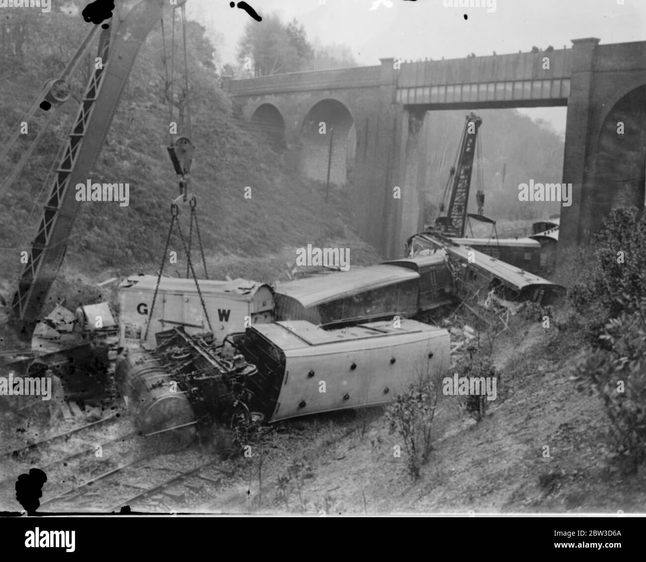 Zug durch Erdrutsch in Hampshire zerstört. Hunderte von Tonnen Erde und Fels, geglaubt, durch die schweren Regenfälle gelockert worden, die bis zur Eisenbahnlinie stürzte völlig zerstört eine Milchbahn in der Nähe von Winchfield, zwischen Flotte und Haken, Hampshire. Alle Gleise wurden gesperrt und der Eisenbahnverkehr wurde gestoppt. Breakdown Banden arbeiten daran, die Linien zu klären. Foto zeigt , Zusammenbruch Banden Clearing der Trümmer . 17. November 1935 Stockfoto