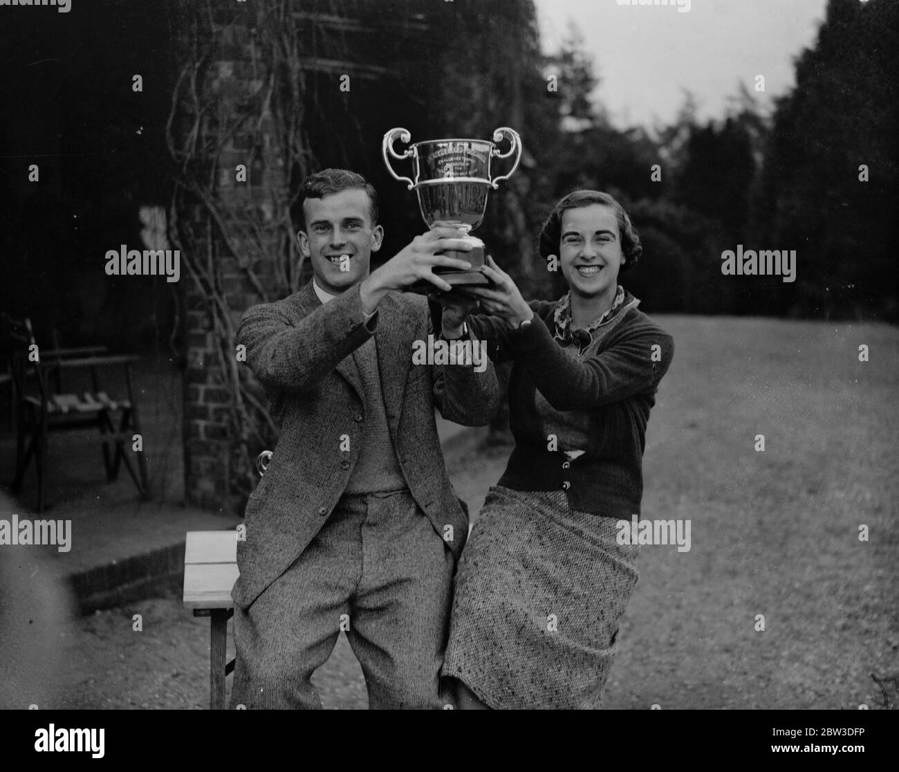 Bruder und Schwester gewinnen Scratch gemischt viersome in Worplesdon, Surrey. Miss Gwen Cradock Hartopp und ihr Bruder John mit dem Meisterschaftspokal. 18. Oktober 1935 Stockfoto