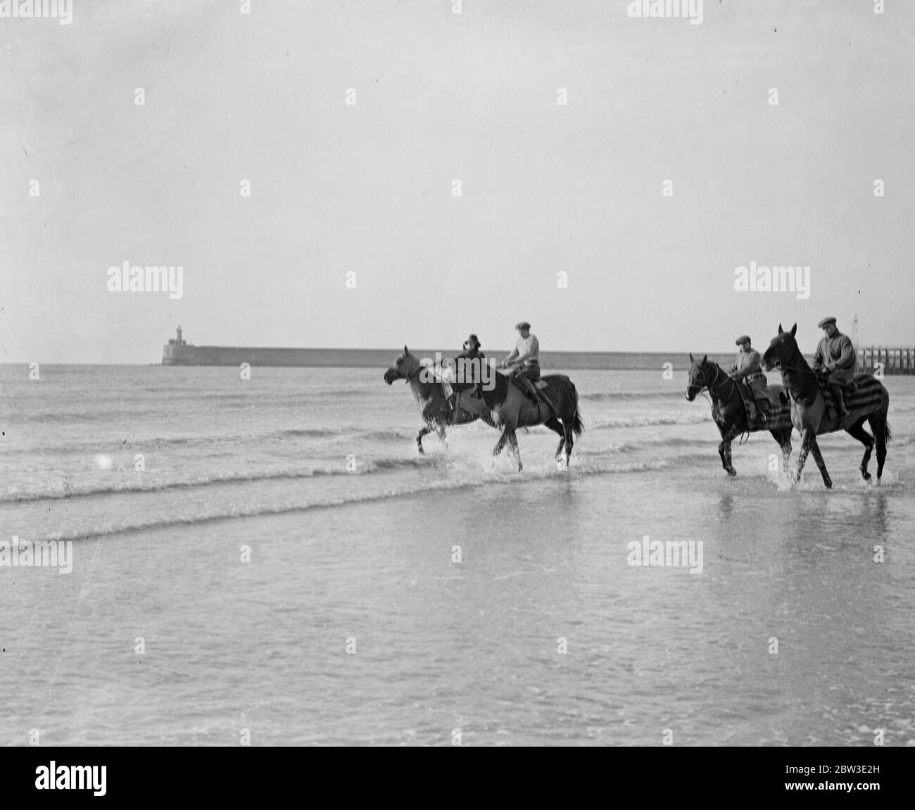 Vier Rennpferde nehmen die Kur in der Brandung in Seaford . Zweite von links ist Master Orange, ein Grand National Kandidat, und auf der rechten Seite ist Cranford St Andrew, das Pferd, das ein Rennen nach der Behandlung gewonnen. Vorne ist Taffets und der dritte von links ist Stop Gap . 10 Februar 1935 Stockfoto