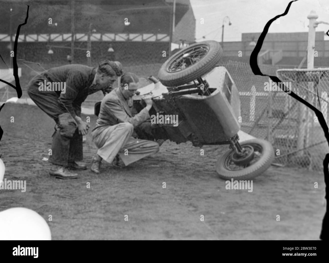 West Ham Speedway zu Midget Autorennen einzuführen. Brooklands Rekordhalter entwirft neues Baby. Foto zeigt Herr G B Bush hob seine Zwergauto mit einer Hand, um eine Anpassung an West Ham von Harold beobachtet machen ( Tiger ) Stevenson . 20 Juni 1935 Stockfoto