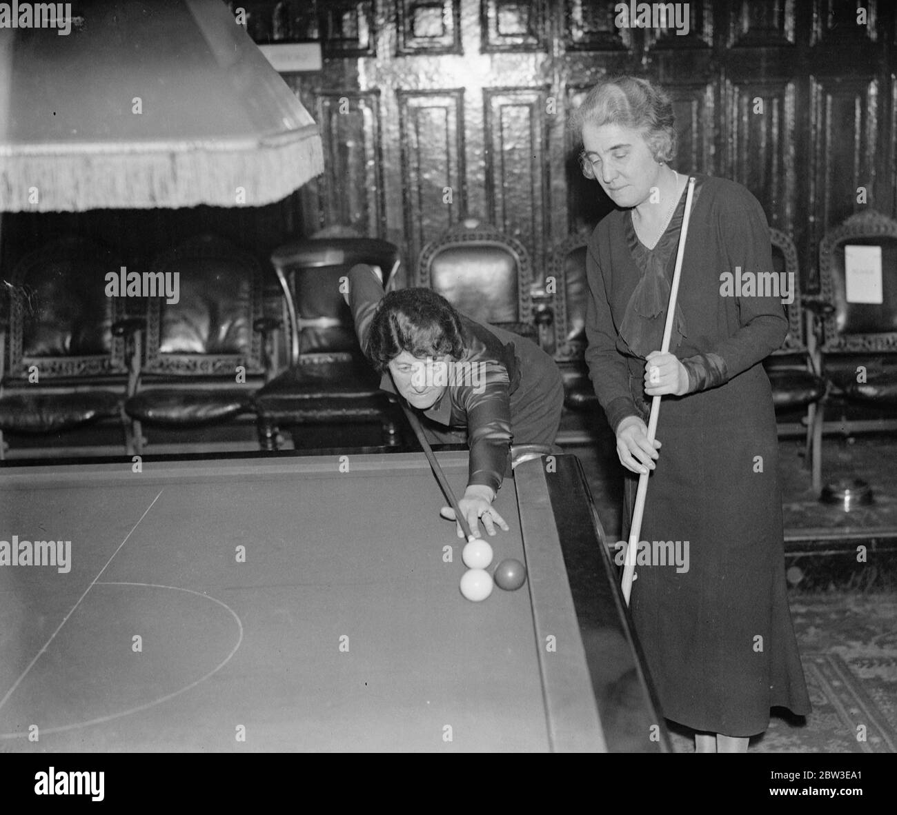 Halbfinale der Amateur-Billard-Meisterschaft der Frauen in Burwat Hall. Frau E Eddowen macht einen Schlaganfall, beobachtet von Frau G Burton in der Burwat Hall. 12 Februar 1935 Stockfoto