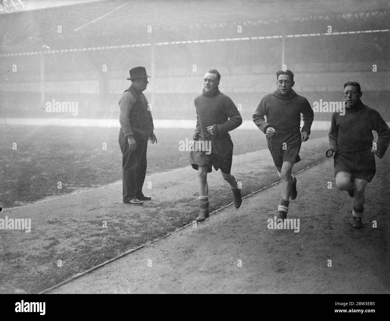 Tottenham ' s Invaliden zurück im Training, George Hunt, Arthur Rowe, und Willie Hall sprinten rund White Hart Lane, von George Hardy, der Clubs Trainer beobachtet. 24. Januar 1935 Stockfoto