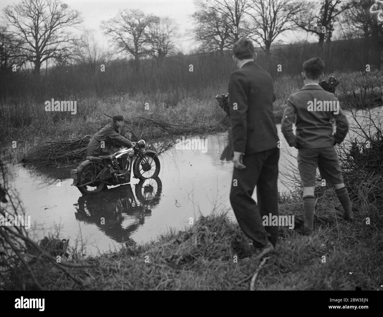 Umfangreiche Überschwemmungen in Berkshire nach feuchtesten Dezember seit 19 Jahren . Ein Motorradfahrer, der Probleme mit dem Hochwasser in Hurst hat. 30 Dezember 1934 Stockfoto