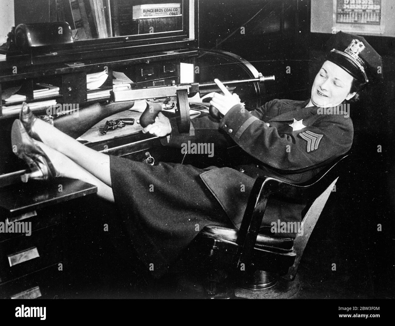 Frauen führen eine Stadt! Für einen Tag übernahmen Frauen die Regierung von Aurora, Illinois, USA, um eine Fahrt gegen ihre Public Enemy No 1, den Bachelor zu führen. Bei dieser Gelegenheit wurden Frauen auf den Polizeistationen und der Stadtfeuerwehr installiert, obwohl glücklicherweise, gab es keine Brände. Foto zeigt, Miss Helen Thompson temporäre Chief of Police, Inspektion ihrer Waffe. 12 März 1936 Stockfoto