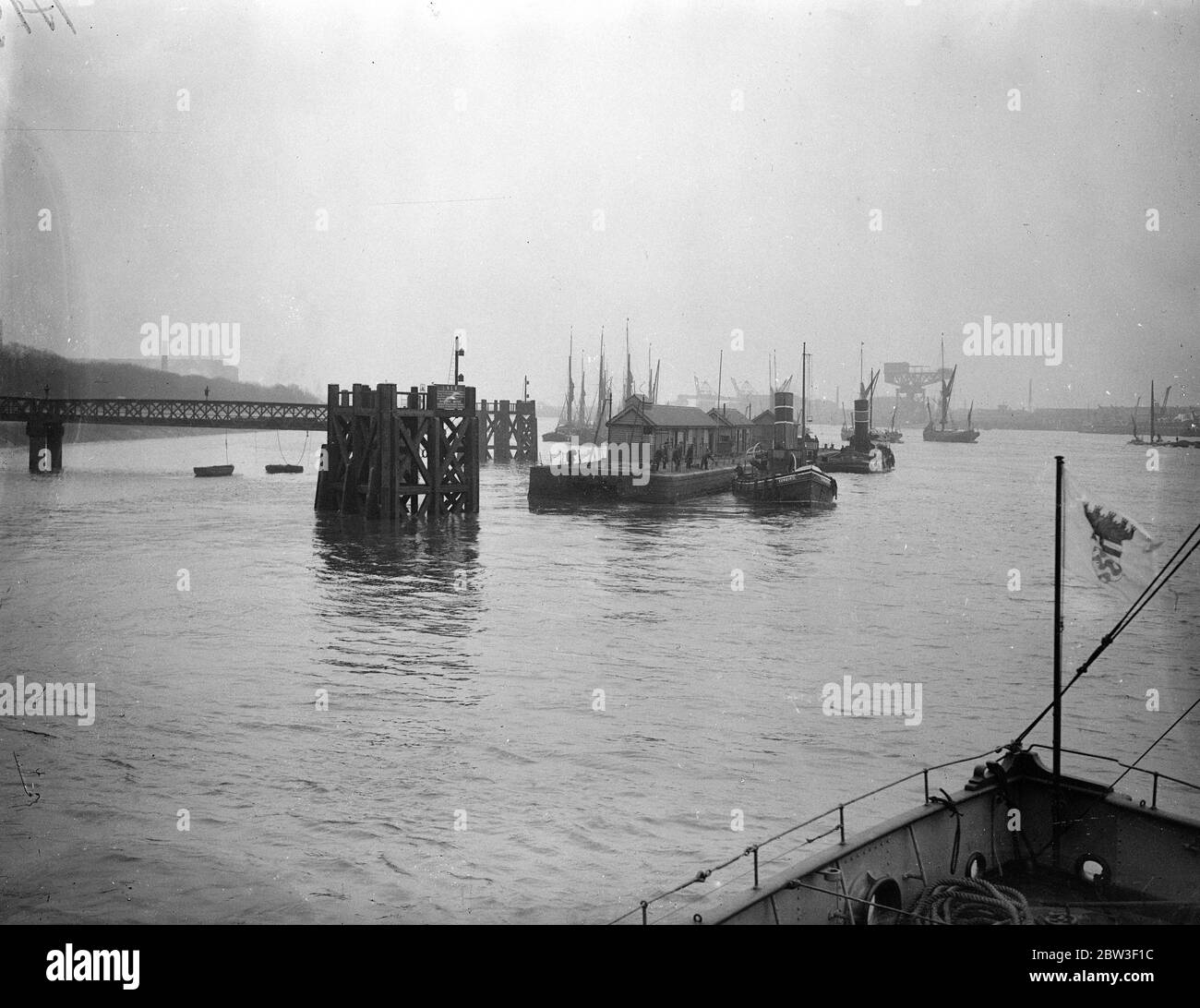 Woolwich Pier geschleppt Fluss für die Renovierung. Woolwich hat vorübergehend seinen Pier verloren, denn es ist jetzt auf dem Weg flussabwärts für Trockendock gebunden, wo es repariert und überholt werden soll. Zwei Schlepper führen das Schlepptau aus. Foto zeigt, Abschleppen Woolwich Pier Fluss hinunter zum Trockendock für Überholung. 11 März 1936 Stockfoto