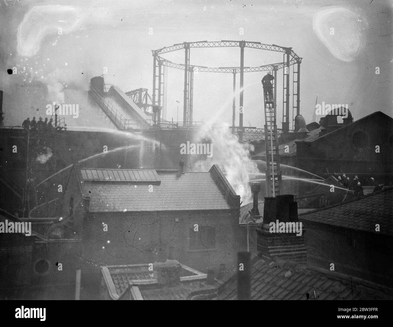Feuerwehrleute bei der Arbeit, die sich mit den großen Gasarbeiten lodern in Wapping, London. 26. Januar 1935 Stockfoto