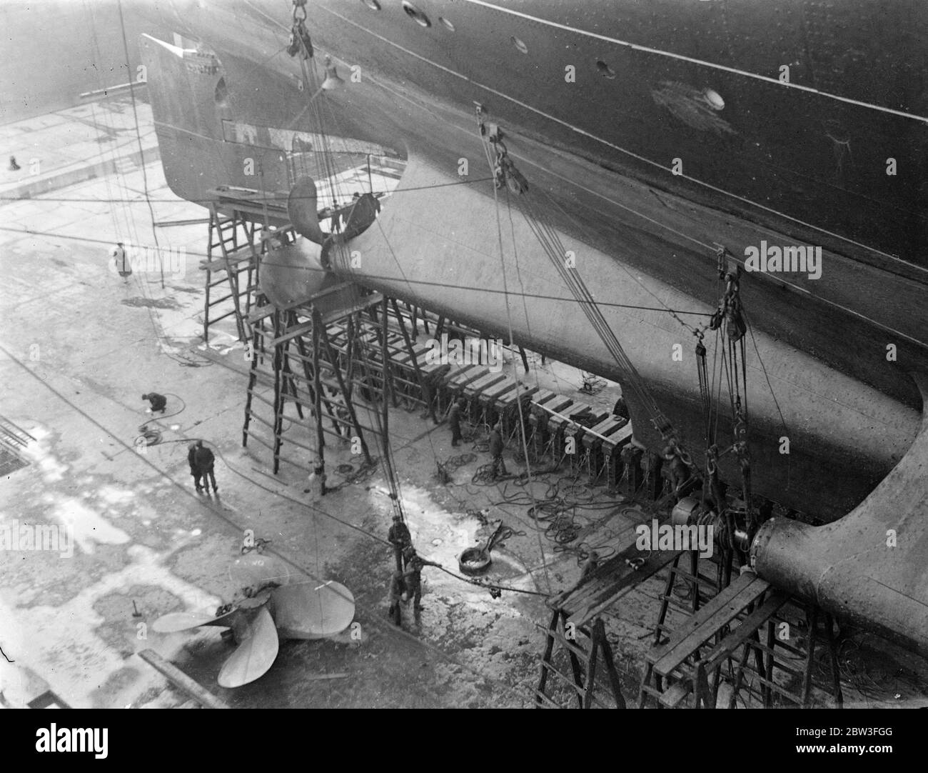 Foto zeigt einen Arbeiter, der in die mächtigen Treibschächte der SS Majestic eingeht, während sie in der riesigen Gravierstation in Southampton ruht. 29. Januar 1935 Stockfoto