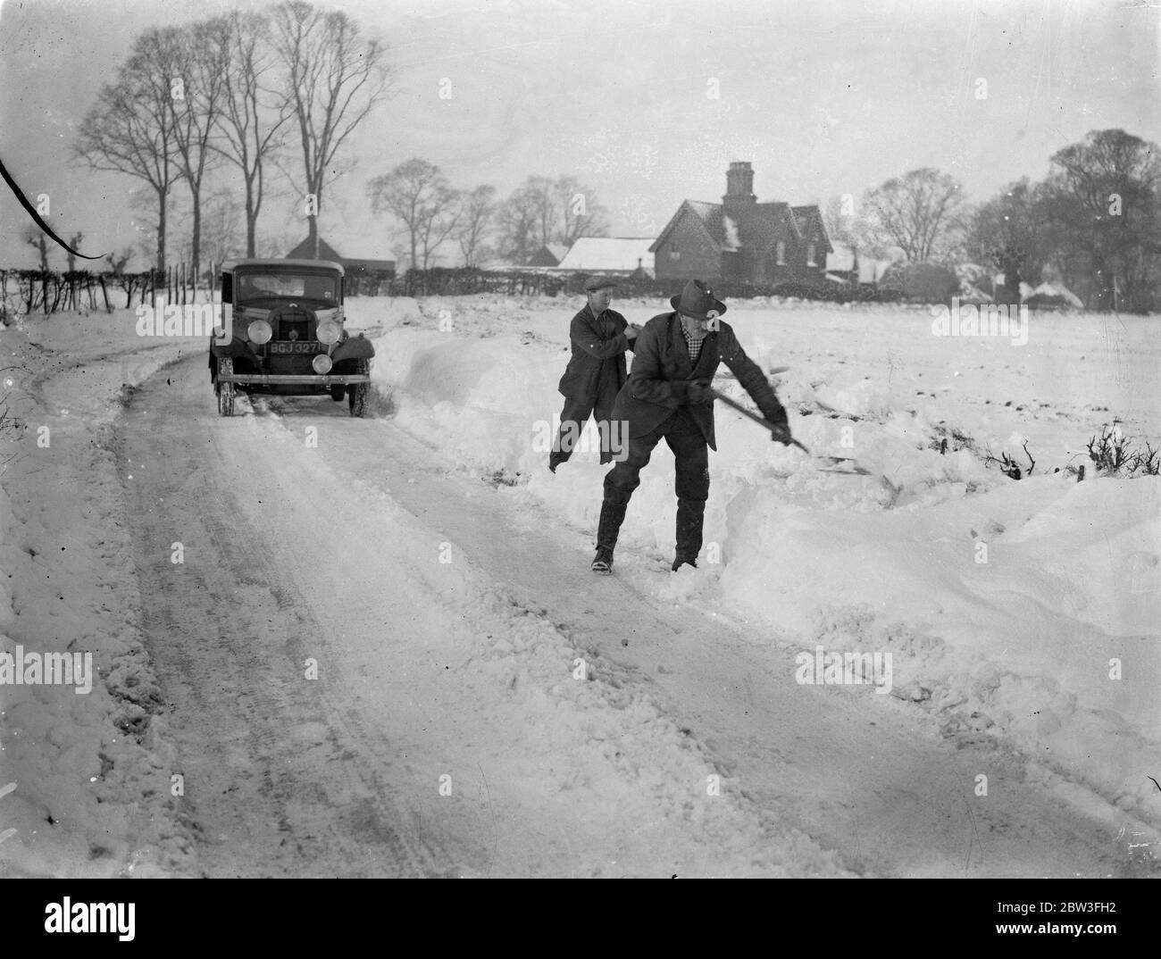 Schneewehen halten den Verkehr in Hertfordshire. Foto zeigt ; Männer, die die Straßen von Schnee. 27. Januar 1935 Stockfoto
