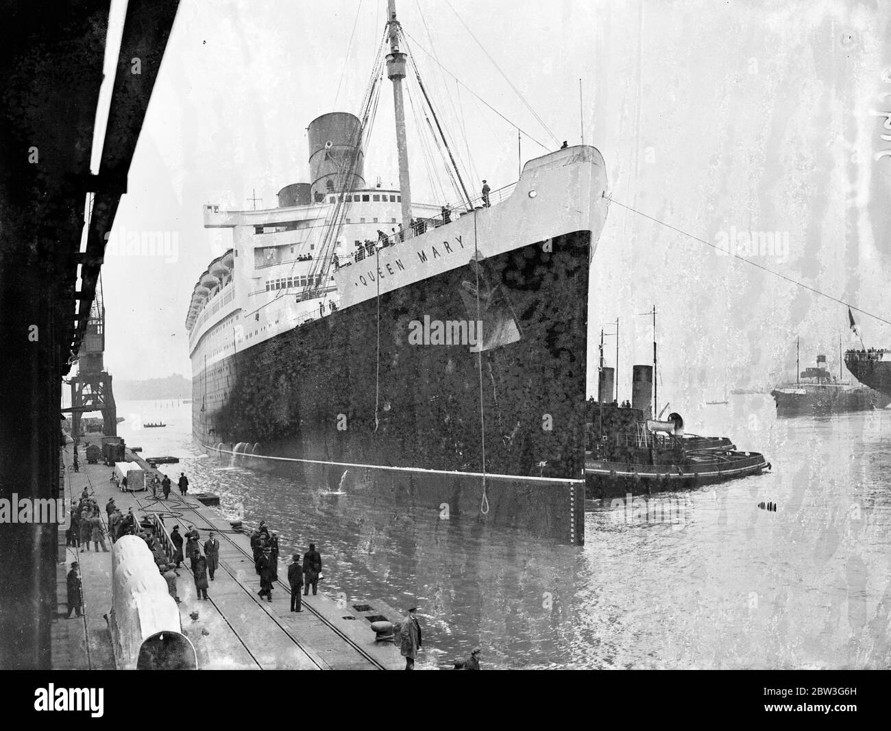 Queen Mary zog zum Meer gehen Liegeplatz von Southampton Trockendock. Der riesige Liner "Queen Mary" wurde von der King George V Graving Dock in Southampton, wo ihre Propeller geändert wurden und ihr Rumpf mit nicht korrosiven Farben beschichtet, zum Ocean Dock verschoben, Das Meer geht Liegeplatz sie besetzen, wenn sie in den Nordatlantik Dienst . Sie wird Southampton nächste Woche verlassen, um ihre Prozesse zu beenden. Foto zeigt, "Queen Mary" Eingabe der Ocean Dock in Southampton. April 1936 Stockfoto