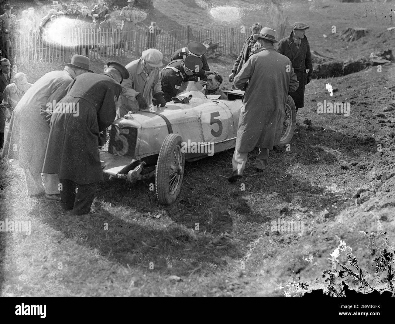 Fahrer entkommt in 100 Meilen eine Stunde Absturz bei British Empire Trophäenrennen . Wel Handley hatte eine erstaunliche Flucht, vor dem Tod, als Freddie Dixon ' s Riley in der 250 Meile British Empire Trophy Race in Donington Park, Derby. Ein paar Minuten nach der Übernahme von Dixon Handley überschob eine Ecke, wenn die Reise mit 100 Meilen pro Stunde . Das Auto verließ die Straße, traf eine niedrige Obstruktion und Sprünge in der Luft umgedreht. Es geradte sich und drehte sich dann immer und immer wieder, um ein rauchendes Wrack zu beenden. Handley wurde praktisch unverletzt vom Fahrersitz gezogen. Wal Handley ist als ein Stockfoto