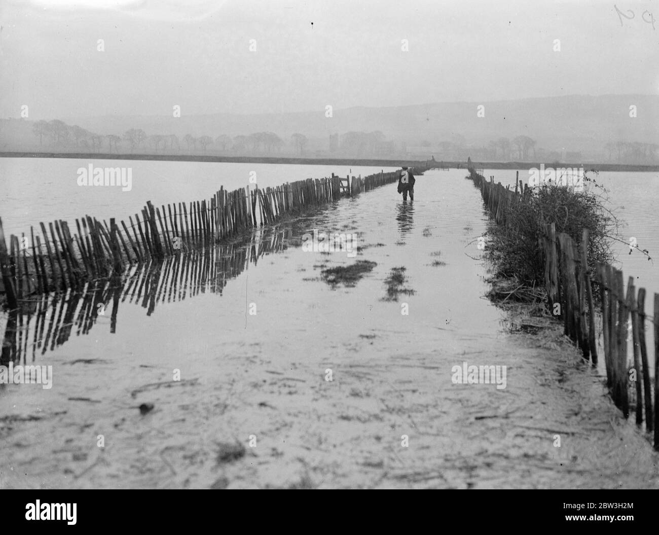 River Medway platzt seine Ufer. Weit verbreitete Überschwemmungen - Bauernhöfe abgeschnitten . Waten durch eine überflutete Straße im Medway Valley. Februar 1935 Stockfoto