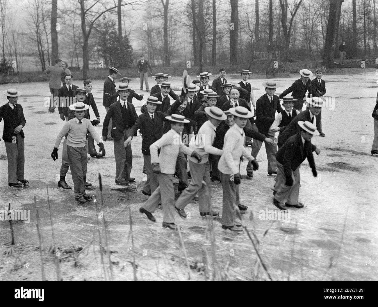 Strohhüte und Schlittschuhe bei Harrow . Mit dem See in der Schule Gelände durch die Kälte eingefroren, haben Harrow School Jungen eine perfekte Eislaufbahn vor ihrer Tür. Alle Jungs entpuppten sich zu skaten, aber auch das kalte Wetter konnte sie nicht dazu bewegen, ihre traditionellen Strohhüte zu vergessen. Telefon zeigt, Harrow Jungen, jeder mit seinem Strohhut, Skaten auf dem gefrorenen See auf dem Schulgelände. 13 Februar 1936 Stockfoto