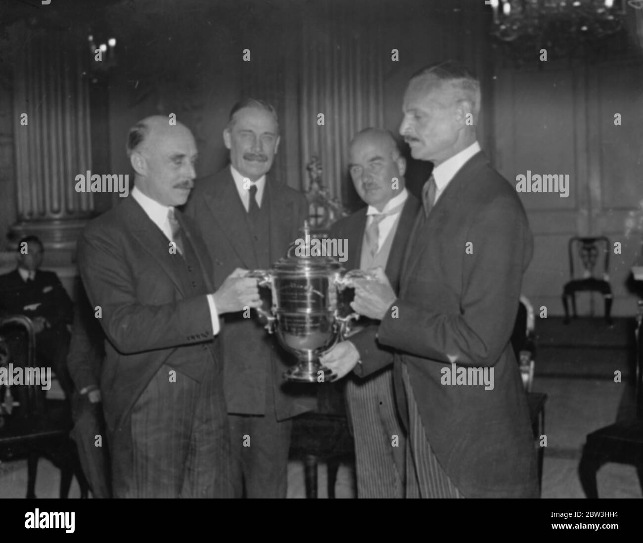 Sir Stephan Tallents wird erster Regierungsbeamter, der den Public Club's Cup erhält. Foto zeigt ; Major Astor (rechts) präsentiert den Pokal Sir Stephen Tallents , hinter sind , links , Major GeorgeTryon , der Postmaster General und Herr A Beverley Baxter . 20 Juni 1935 Stockfoto