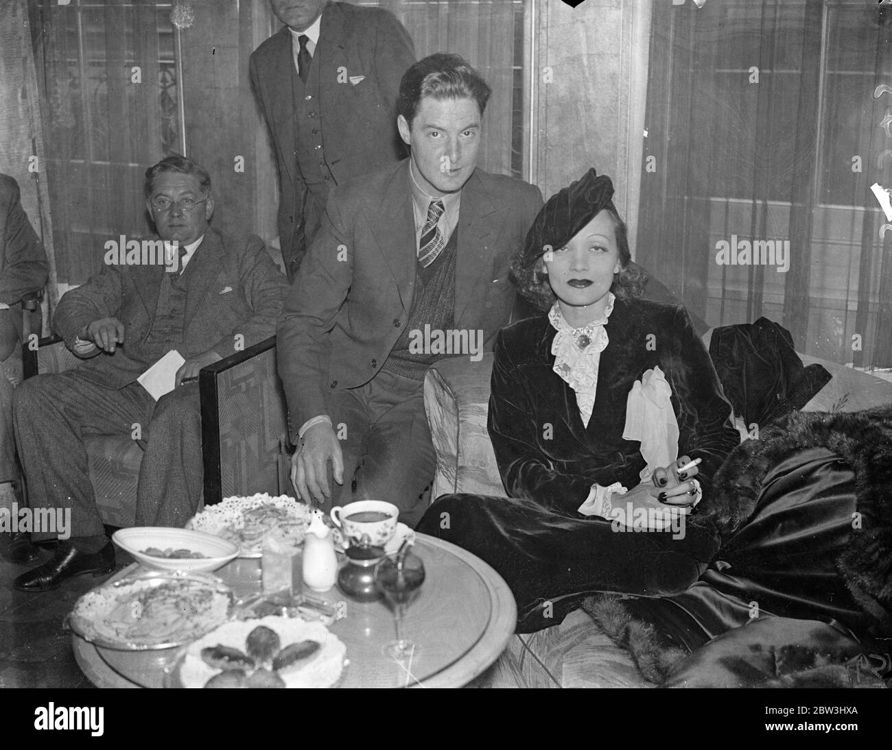 Marlene Dietrich gibt die Rezeption bei der Ankunft in London. Unmittelbar nach ihrer Ankunft in London aus Hollywood, Marlene Diatrich, die deutsche Filmschauspielerin, gab einen Empfang in Claridge ' s, Brook Street, Miss Dietrich ist in London angekommen, um einen Film in britischen Studios zu machen. Sie wird begleitet von ihrem Mann Herr Rudolph Sieber. Foto zeigt, Marlene Dietrich mit Robert Donat, dem englischen ilm Schauspieler bei Claridge. 30 Juli 1936 Stockfoto