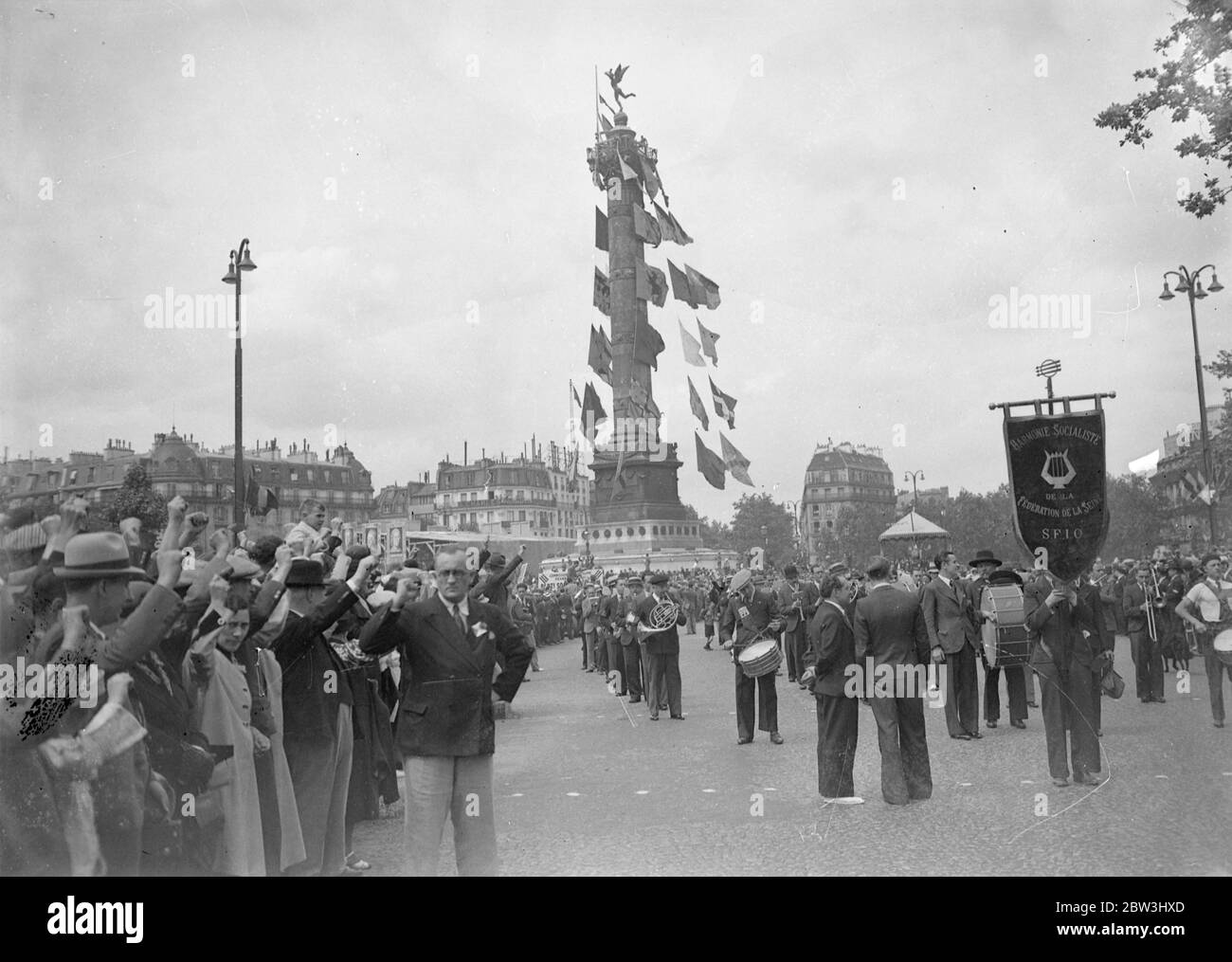 Volksfront Mitglieder Parade In Paris Während Jahrestag Feiern Des Falls Der Bastille . Tausende von Mitgliedern der Volksfront, angeführt von ihren Führern, marschierten durch die fröhlich geschmückten Straßen von Paris in Monster Prozessionen während der Jubiläumsfeiern des Falls der Bastille in der Französischen Revolution. Große Kräfte der Polizei und mobile Wachen patrouillierten auf den Straßen, um Unruhen zu verhindern. Foto zeigt: Menschenmenge auf dem Place de la Bastille, Paris, die den kommunistischen Gruß. Juli 1936, 14 Stockfoto