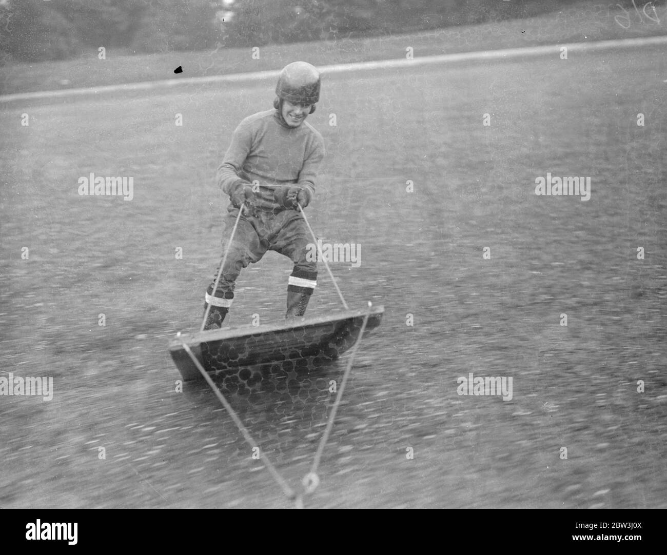 Sie ist ein zerschmetterischen Reiter ! . Eine Platte aus Tellerglas verursacht weniger Ärger für Jessie Hole, furchtloses Mädchen Motorradfahrer, als eine Ampel! , auf diesem Bild sieht man sie eine Glasbarriere zerschlagen, während sie mit dem Kopf nach unten im Crystal Palace, London, durchreitet. 12 Juli 1936 Stockfoto