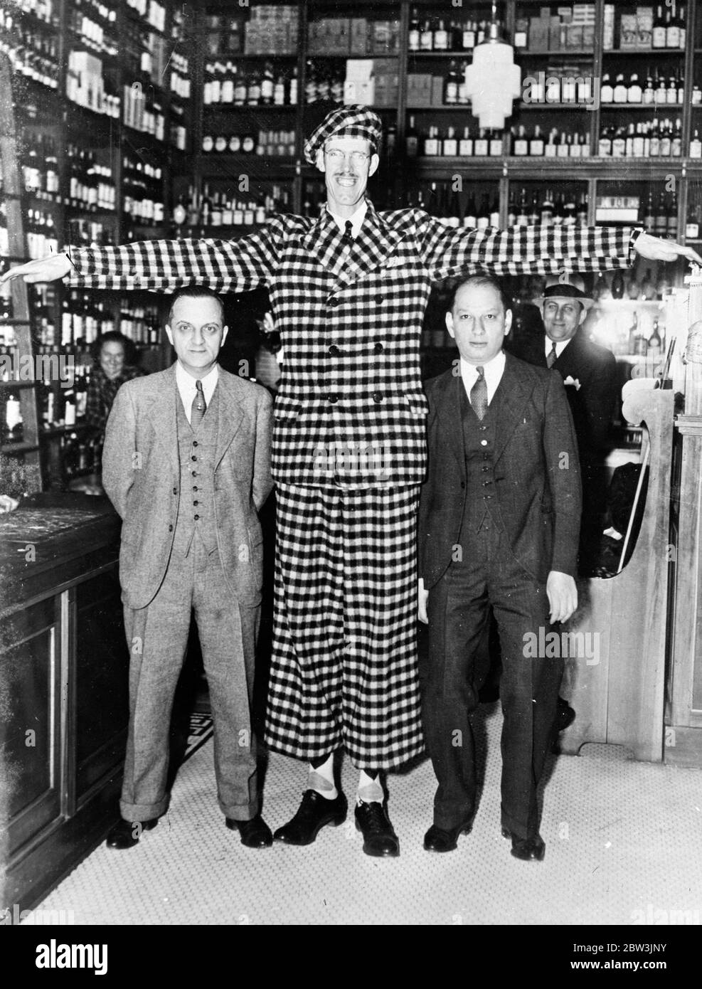 Er sollte sich wohl fühlen unter den Himmel scapers. Chester Cass ein Londoner 7 Fuß 6 Zoll groß, hat in New York auf einer drei Monate, Tour durch die Vereinigten Staaten angekommen. Foto zeigt, Chester Cass im Vergleich zu S Freund (links) und Sam Saffran, in New York. Bis 21. August 1935 Stockfoto