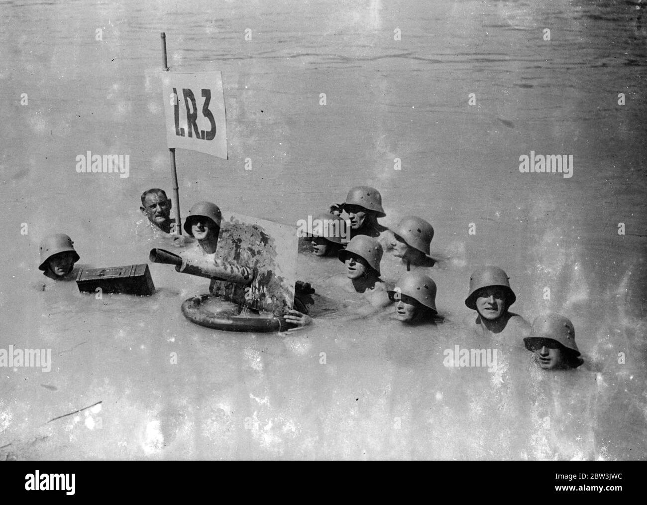 Australische Truppen Verwenden Schwimmende Maschine - Gun . Kanonier Schwimmen In Stahl - Helme . Eine Demonstration, wie eine Maschinenpistole von durch Wasser schwimmenden Truppen bedient werden kann, wurde in Wien gezeigt. Die Maschine - Pistole ist auf einem Gummischwimmer montiert , Munition in einem Wasser - Proof Fall enthalten . Foto zeigt : Stahl - Helmeted österreichischen Maschine - Gunners Betrieb ihre Waffe, wie sie schwimmen . Juli 1936 Stockfoto