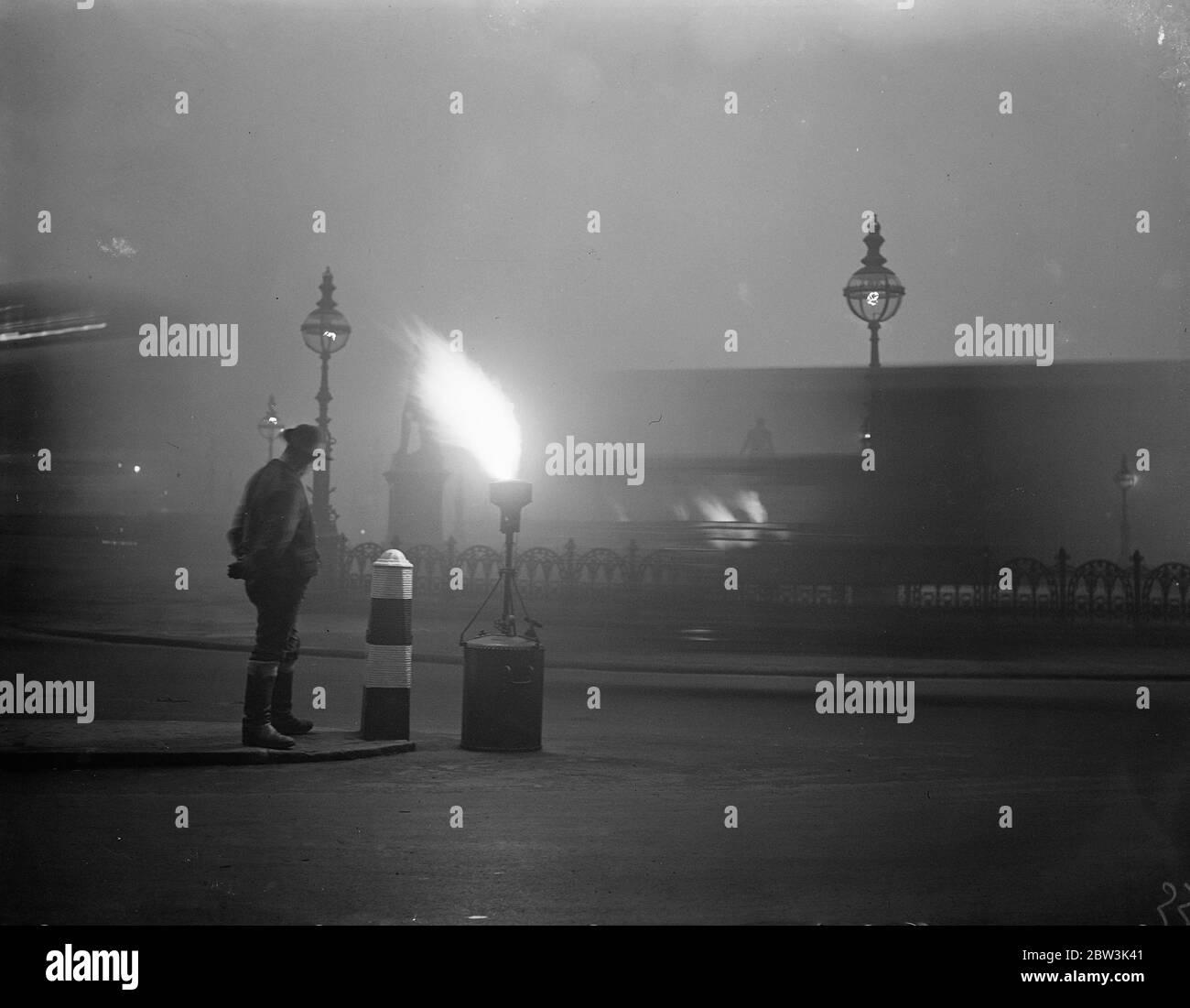 Fackeln im Nebel gebunden London . Nebelgasfackeln wurden mittags auf dem Damm angezündet. Dezember 1935 Stockfoto