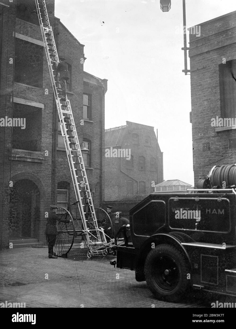 West Ham Feuerwehrmotor wie ein Reisebus. Eine neue Feuerwehrmaschine, in deren Front sind Sitze so angeordnet, dass die Feuerwehrleute sitzen Motor-Coach Mode hinter dem Fahrer und Offizier wurde von West Ham Feuerwehr freigesprochen. Montiert auf dem Motor ist eine neue 50 Fuß Feuerschutzabbruchfläche komplett aus Stahl. Es gibt eine Pumpe an beiden Seiten in der Lage, 800 Gallonen Wasser pro Minute liefern. Foto zeigt, West Ham Feuerwehrleute, die Demonstration der neuen 50 Meter alle Stahl Feuerausbruchstellen. 10 Dezember 1935 Stockfoto