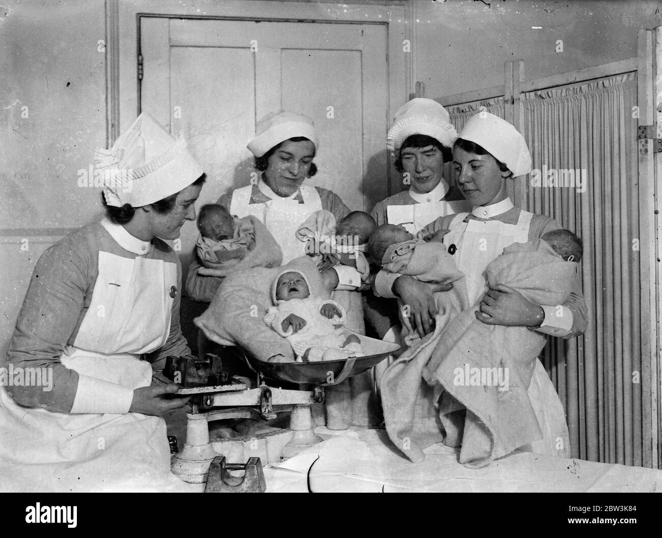 Mit weit geöffneten Mündern. Zehn Weihnachtsbabys im Queen Charlotte 's Hospital. Wiegen einige der Weihnachtsbabys im Queen Charlotte 's Hospital. Einige von ihnen scheinen ihre Enthüllungen mit viel Energie zu entlüften. 26 Dezember 1935 Stockfoto