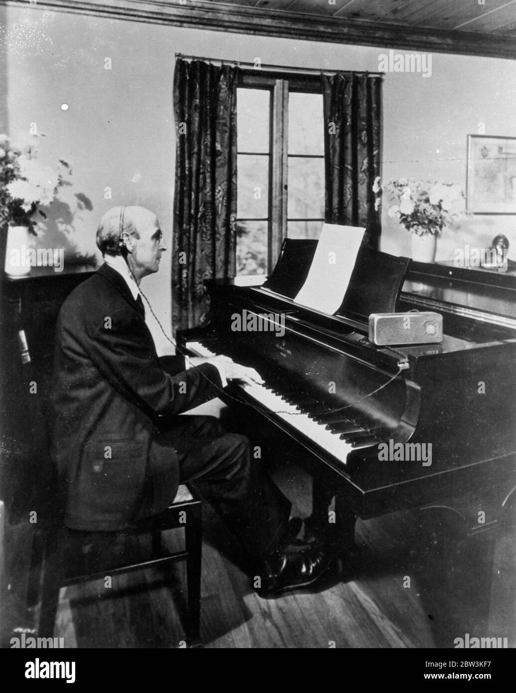 Hören durch Bohrungen des Kopfes . Sein Gehör seit seiner Jugend betroffen und jetzt fast vollständig verschwunden , Herr Frank W Becket , ein New Yorker Investmentmakler , führt nicht nur seine Geschäfts , sondern auch weiterhin sein Leben lang Hobby-Musik zu pflegen . Er ist Komponist und ein versierter Pianist und wurde vor kurzem ausgewählt, um seine eigenen Kompositionen zu übertragen. Becket überwand seinen unheilbaren Verlust durch elektrisches Hören. Er hört elektrisch durch die Knochen seines Kopfes mit einem speziellen Apparat. Foto zeigt, Herr Frank W Becket spielt eine seiner eigenen Kompositionen und hört sie elektrisch durch Stockfoto