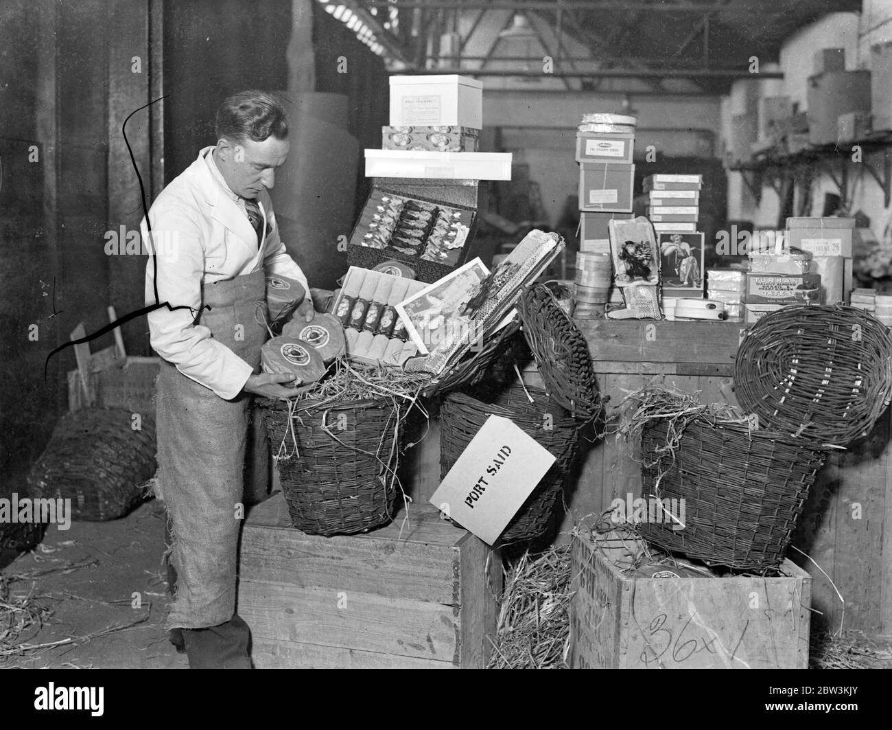 Naffy geht alle aus, um Truppen ein fröhliches weihnachten zu geben. "Naffy" , die Marine-, Armee- und Luftwaffeninstitute, arbeiten unter vollem Druck, um sicherzustellen, dass die Männer der Dienste ein fröhliches Weihnachten auf der ganzen Welt haben. Weihnachtsgeld wird in Hampers verpackt und Spielzeug wird in Kisten in den Lagerhäusern in Kennington, zum Versand verpackt. Foto zeigt, Verpackung Spielzeug für Columbo in der Zentrale Lagerhallen. 27. November 1935 Stockfoto