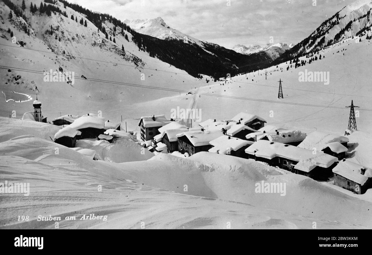 Schnell im Winter eisiger Griff. Fast versteckt unter einem tiefen weißen Mantke schmiegt sich dieses Bergdorf sicher unter die schneebedeckten Gipfel des majestätischen Arlbergs Österreichs. 13 Dezember 1935 Stockfoto