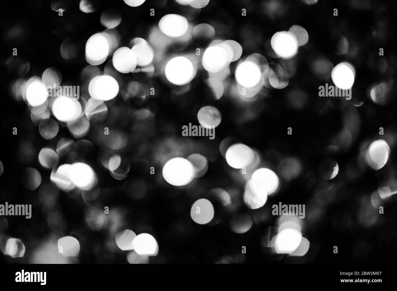 Schwarz-weiße Kreise Bokeh festliche Glitzer dunklen Hintergrund. Weihnachtslichter Bokeh Overlay-Muster. Modernes abstraktes Design. Stockfoto