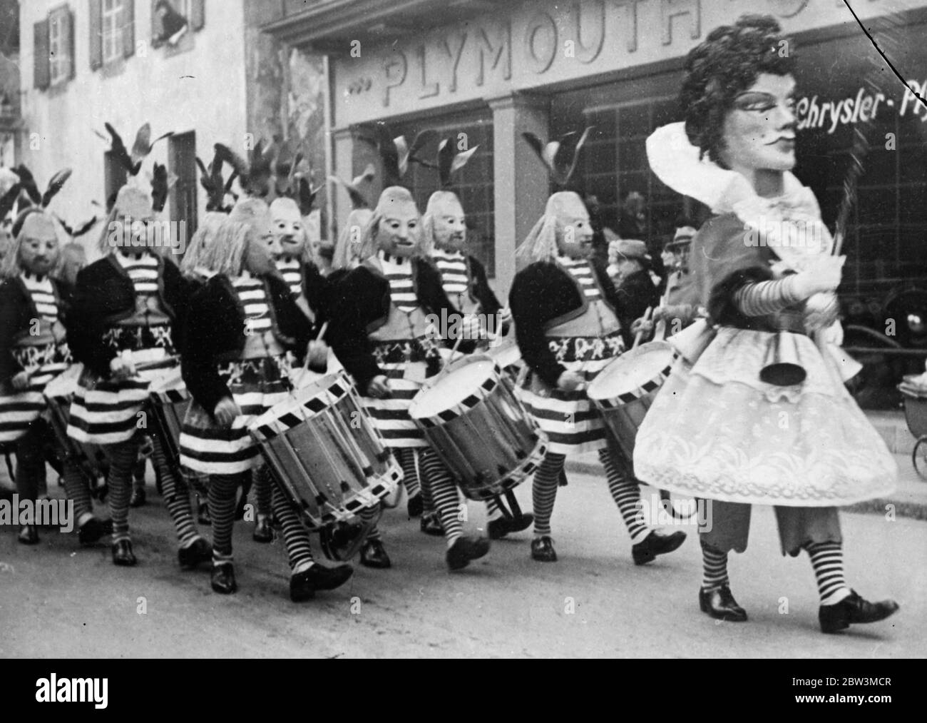 Wachs maskierte Trommler führen jährliche Basel Festival Prozession. Seltsame Kostüme und Karneval Fröhlichkeit . Fahtesisch aber malerisch kostümierte, Alptraum-Figuren parierten während des weltberühmten Jahresfests in der Altschweizerstadt durch die Straßen von Basel. Riesige Bildchen, in vielen Farben gekleidet, führte die lange Prozession zum Besten der schräg maskierten Trommler. Foto zeigt, Wachs maskierte Trommler, mit Bier Zapfnase und langen Seil Schnurrbärte, die Führung der Basel Festival Prozession. März 1936 Stockfoto