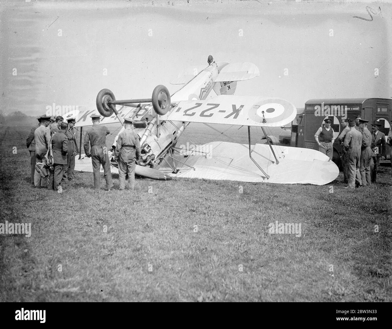 Ein Bristol Bulldog Mk II A von No. 17 Squadron Royal Air Force an der Royal Air Force Station Kenley, Surrey, Registrierung K2216 nach seinem Unfall (links), in dem bei der Landung beim Bremsen das Flugzeug umgedreht. Der Pilot wurde den Absturz lebendig gelassen, aber der Flugzeugschaden war nicht repariert. Der Absturz ereignete sich während der Proben für Empire Air Day, der in diesem Monat stattfinden soll. An diesem Tag werden die RAF-Flugplätze für die öffentliche Inspektion geöffnet. Foto zeigt Bodenpersonal Inspektion der abgestürzten Flugzeug. Mai 1936 Stockfoto