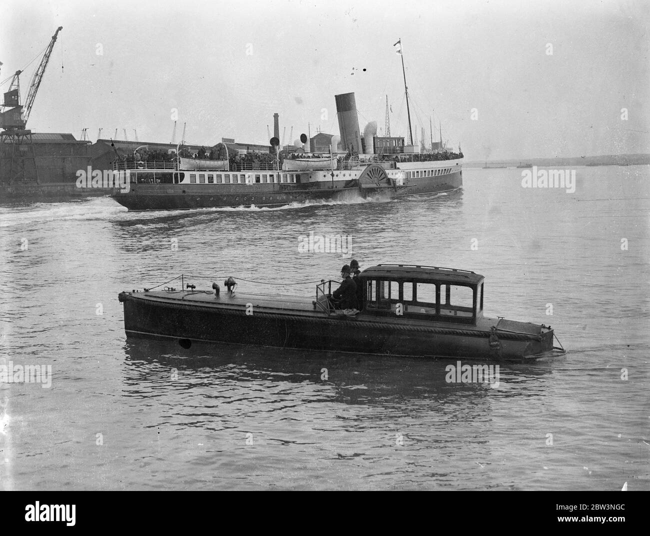 Polizeiwache 'Queen Mary' von den Sehenswürdigkeiten in Southampton. Tausende von Ostern Besucher . Die Polizei von Southampton hatte einen wässrigen Schlag, als Tausende von Osterurlaubern ankamen, um die "Queen Mary" zu inspizieren. Zwei uniformierte Polizisten waren in einem Schnellboot im Einsatz, um unerlaubte Vergnügungsboote daran zu hindern, in das Ocean Dock einzusteigen, wo der riesige Linienschiff liegt. Foto zeigt, uniformierte Polizei Bewachung der Ocean Dock in einem Schnellboot als Vergnügen Dampfer Pässe. 13. April 1936 Stockfoto