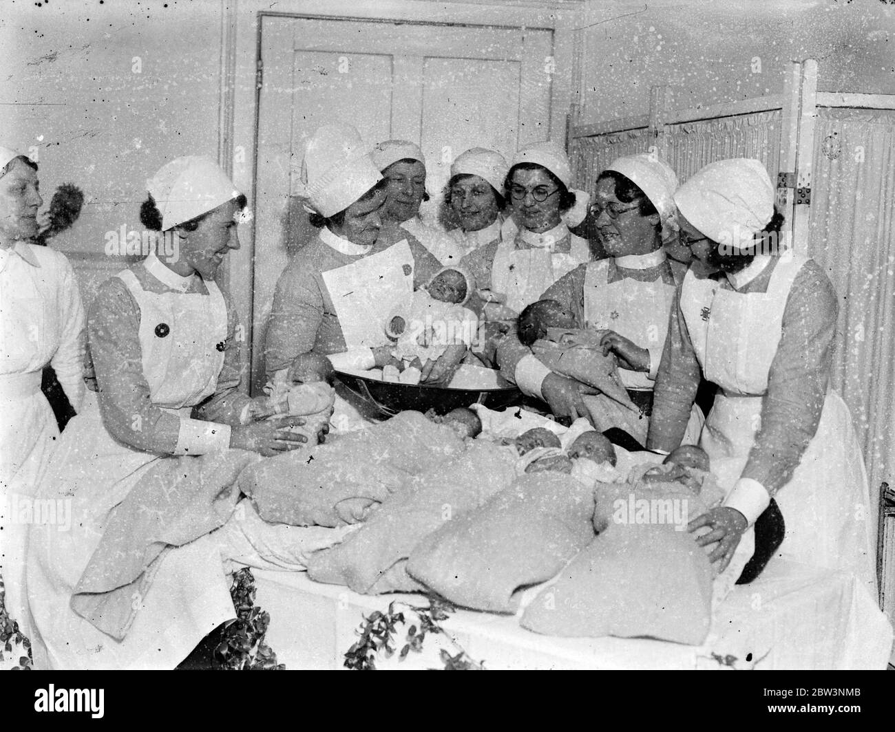 Mit weit geöffneten Mündern. Zehn Weihnachtsbabys im Queen Charlotte 's Hospital. Wiegen einige der Weihnachtsbabys im Queen Charlotte 's Hospital. Einige von ihnen scheinen ihre Enthüllungen mit viel Energie zu entlüften. 26 Dezember 1935 Stockfoto