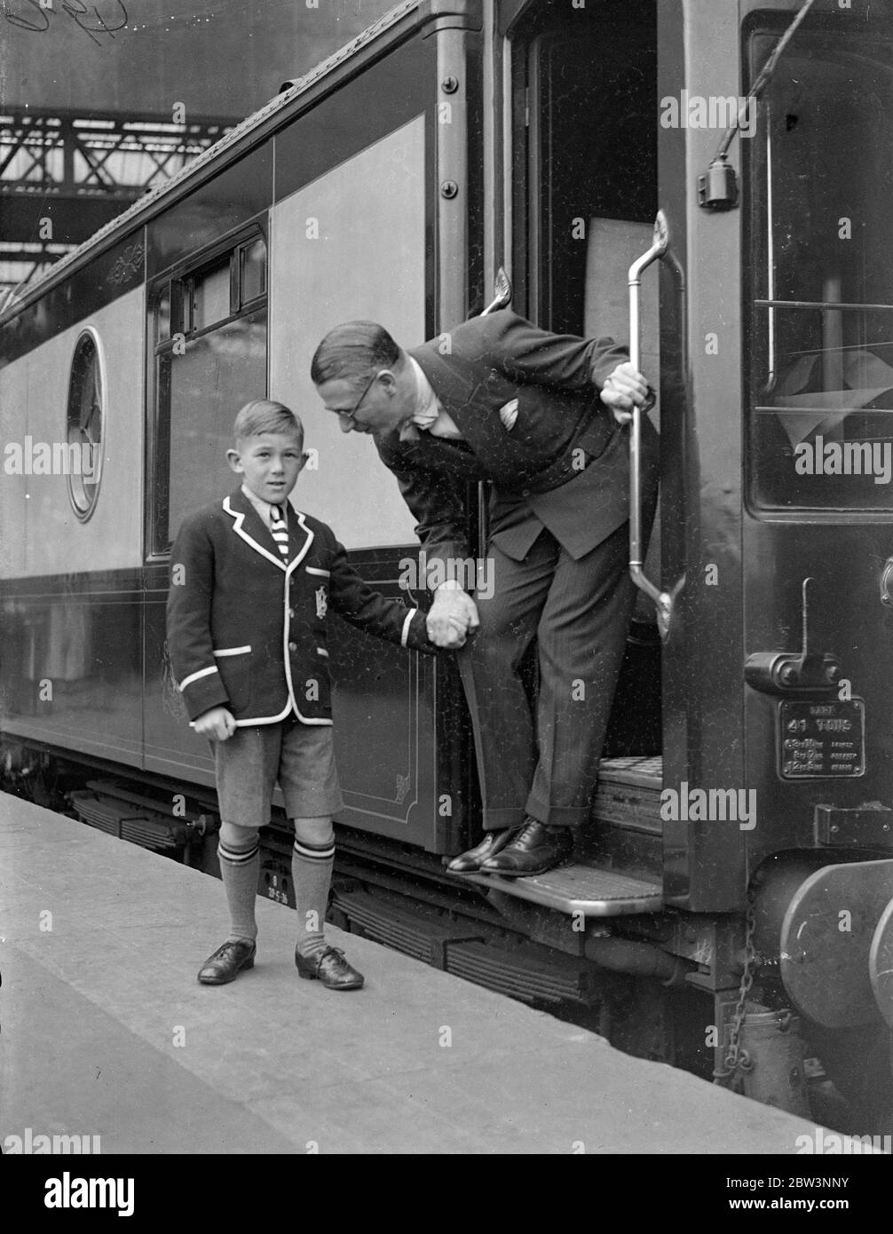 Henry Hall . 'RMS Queen Mary' Gastdirigent verlässt Waterloo auf dem Bootszug. Henry Hall , Leiter der BBC Dance Band, der Gastdirigent an Bord der "RMS Queen Mary" auf ihrer Jungfernfahrt sein soll, verließ Waterloo Station auf dem Bootstrian, um den Linienschiff in Southampton zu besteigen. Auf der Reise, Hall ist es, Konzerte nach England und Amerika zu übertragen. Foto zeigt, Henry Hall Bieten Abschied von seinem Sohn Michael in Waterloo. 27 Mai 1936 Stockfoto