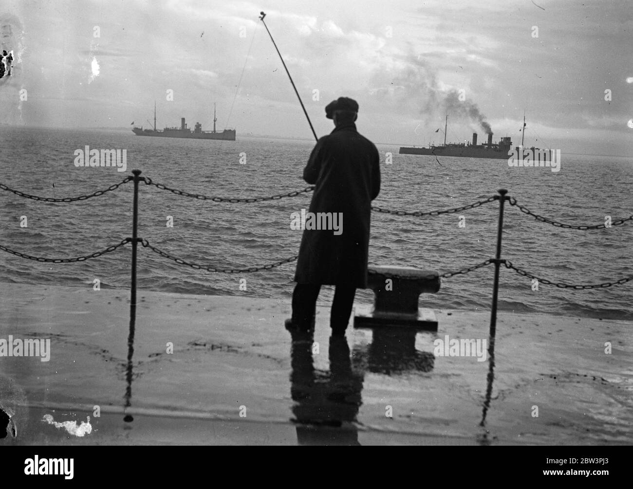 Er hat ein Mystery-Kriegsschiff angespannt. Der belgische Mystery Zerstörer von einem Fischer angespannt . In der Ferne ist die portugiesische Schiffstransport Gil Eanes. Oktober 1935 Stockfoto
