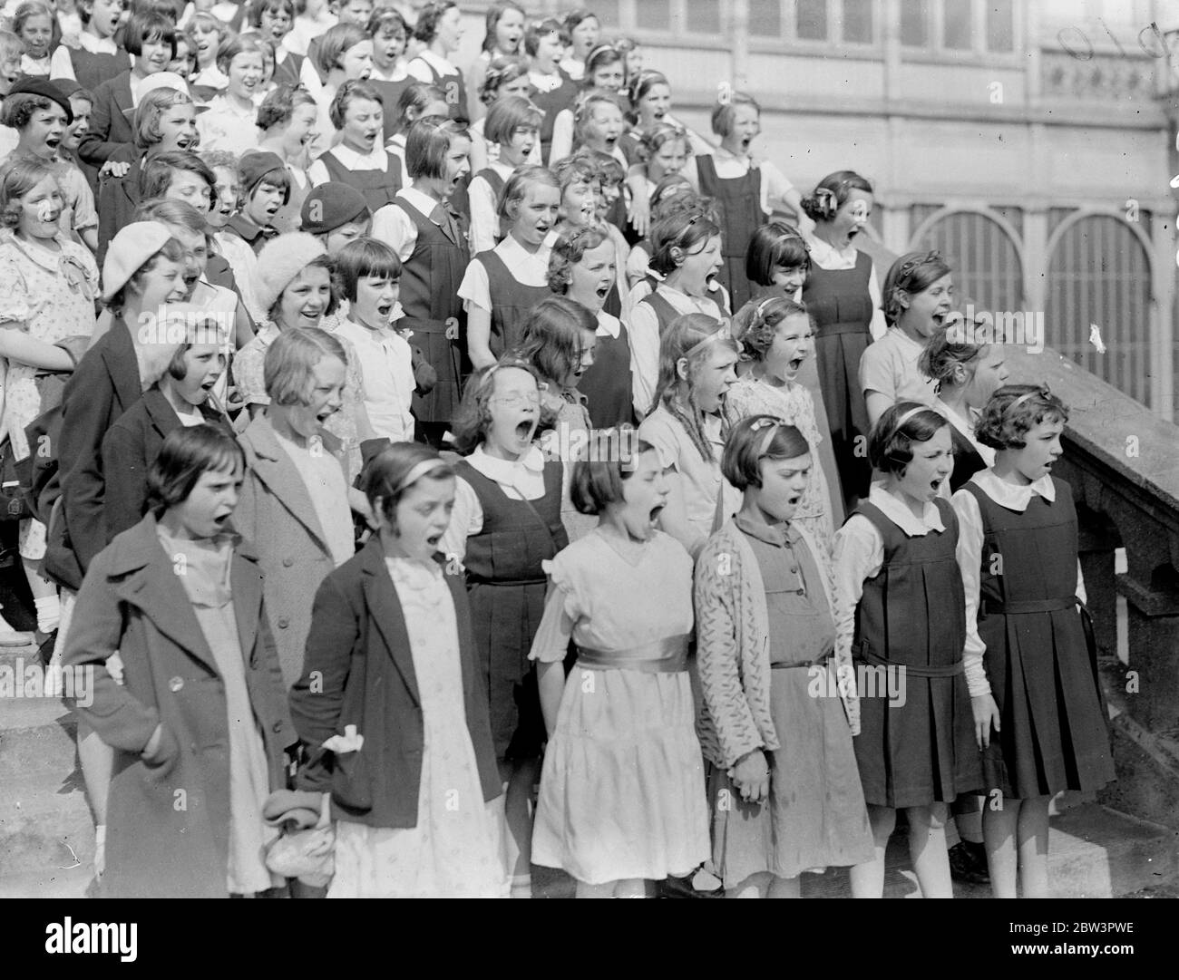 Chrystal Palace Echoes für Kinder Stimmen viertausend in Chorfestival. Viertausend Kinder nehmen am 74. Jährlichen Chorfestival der English Schools' Music Association im Crystal Palace Teil. Zwanzig - sieben Teams sind für einen Volkstanz Wettbewerb eingetragen und Jungen und Mädchen von fünf Jahren dirigieren ihre Percussion Orchester . Foto zeigt: Kinder nehmen an Chorwettbewerb Tuning auf den Stufen des Crystal Palace. 16 Mai 1936 Stockfoto