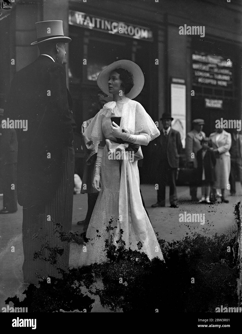 Ascot Mode mit einer Schleife. Waterloo Station nahm auf ungewohnte Eleganz, wenn modische Massen für Ascot links , die heute öffnet ( Dienstag ) . Foto zeigt, ein langes Kleid mit großer Schleife bei Waterloo. Juni 1936 Stockfoto