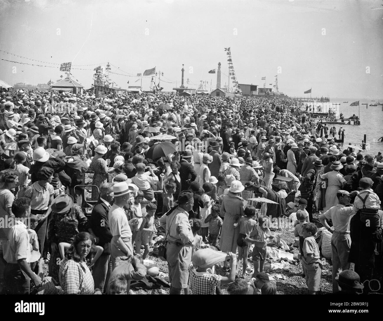 Riesige Menschenmassen in Portsmouth für eine Bewertung. Tolle Menschenmassen warten auf der Portsmouth bis Gosport Fähranlegestelle, um Boote zu ihren Positionen für die King 's Marine Review zu bekommen. Die Royal Yacht Victoria und Albert ist im Hintergrund. 16 Juli 1935 Stockfoto