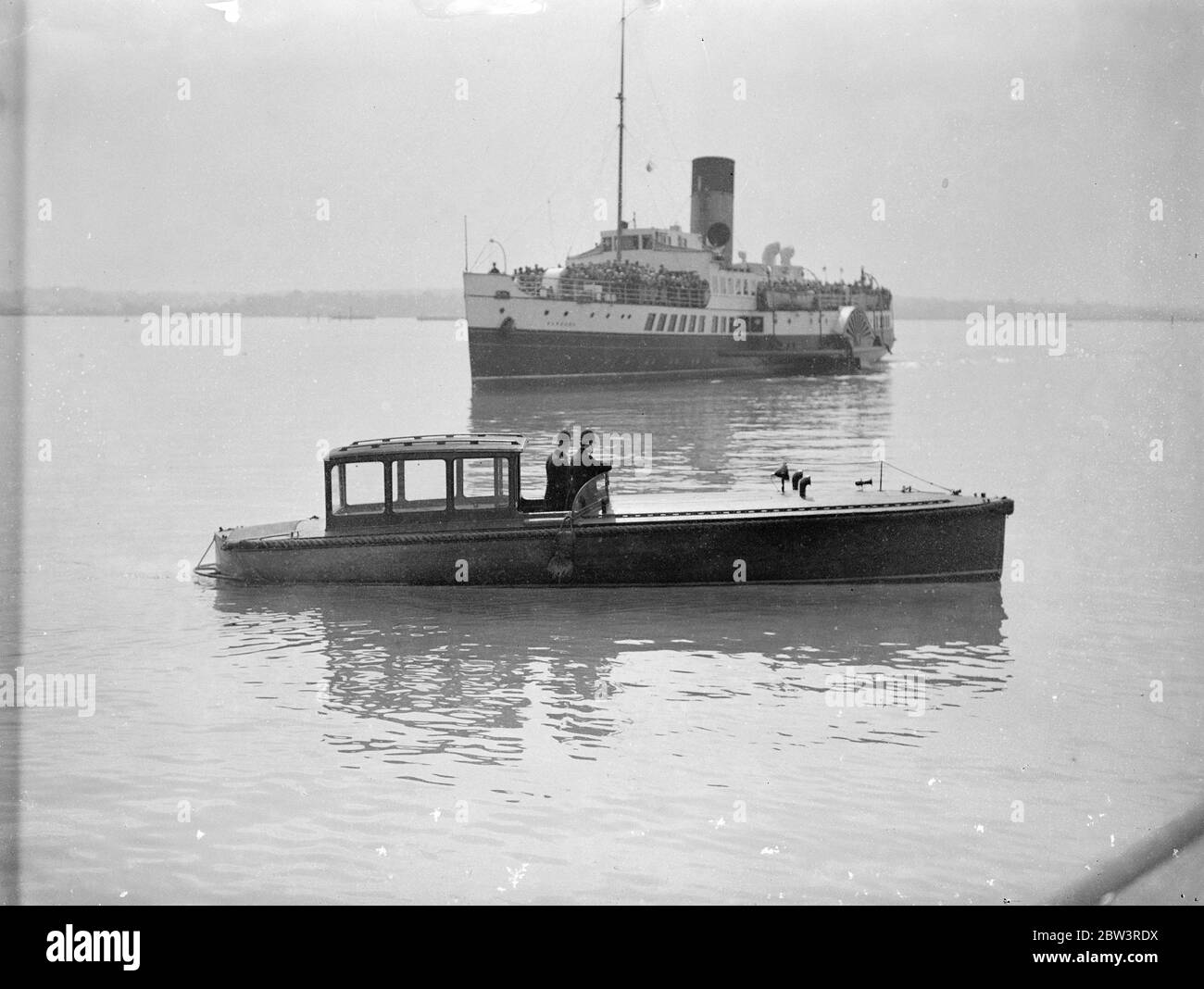 Polizeiwache 'Queen Mary' von den Sehenswürdigkeiten in Southampton. Tausende von Ostern Besucher . Die Polizei von Southampton hatte einen wässrigen Schlag, als Tausende von Osterurlaubern ankamen, um die "Queen Mary" zu inspizieren. Zwei uniformierte Polizisten waren in einem Schnellboot im Einsatz, um unerlaubte Vergnügungsboote daran zu hindern, in das Ocean Dock einzusteigen, wo der riesige Linienschiff liegt. Foto zeigt, uniformierte Polizei Bewachung der Ocean Dock in einem Schnellboot als Vergnügen Dampfer Pässe. 13. April 1936 Stockfoto