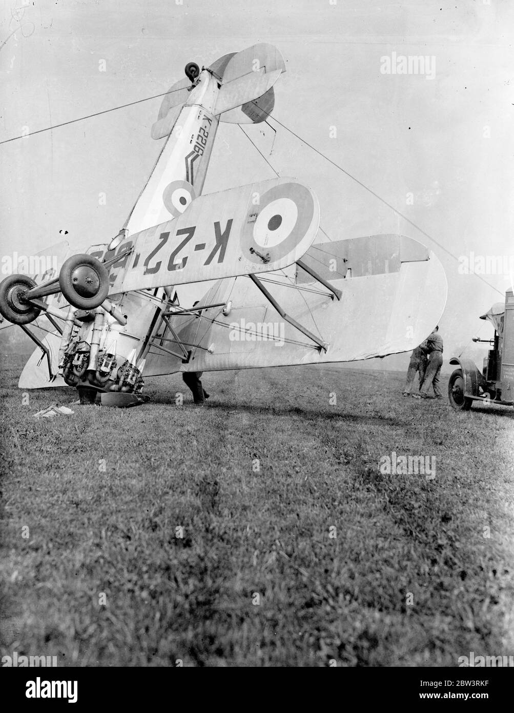 Ein Bristol Bulldog Mk II A von No. 17 Squadron Royal Air Force an der Royal Air Force Station Kenley, Surrey, Registrierung K2216 nach seinem Unfall (links), in dem bei der Landung beim Bremsen das Flugzeug umgedreht. Der Pilot wurde den Absturz lebendig gelassen, aber der Flugzeugschaden war nicht repariert. Der Absturz ereignete sich während der Proben für Empire Air Day, der in diesem Monat stattfinden soll. An diesem Tag werden die RAF-Flugplätze für die öffentliche Inspektion geöffnet. Foto zeigt s die Bristol Bulldog wird durch Boden persönlichen nach Unfall geradelt . Mai 1936 Stockfoto