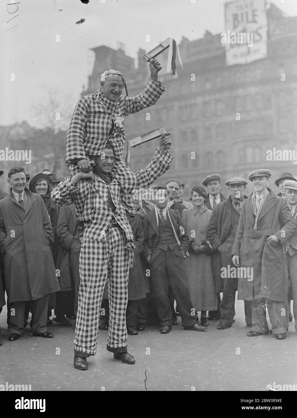 Sheffield Anhänger haben eine "rasseln" gute Zeit in London. Tausende Fans des Sheffield United Cup Final bereisen London, bevor sie zum großen Spiel nach Wembley fahren. Foto zeigt, EIN Anhänger von Sheffield schwingt seine Rassel von den breiten Schultern eines Genossen auf dem Trafalgar Square. 25. April 1936 Stockfoto