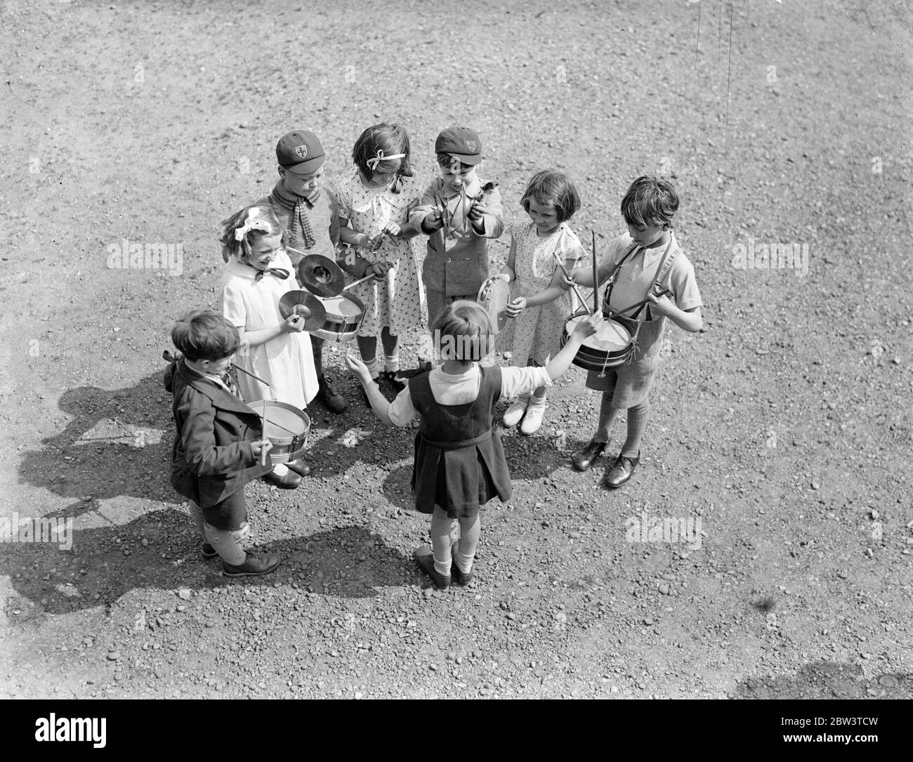 Ein fünf - Jahr - alter Dirigent beim Crystal Palace Music Festival . Jungs und Mädchen von fünf Jahren dirigieren ihre eigenen Percussion-Bands beim 74. Jährlichen Chorfestival der English Schools' Music Association, in dem 4000 Kinder am Crystal Palace teilnehmen. Zehn Kinder Percussion Bands aus verschiedenen Schulen nehmen an einem Wettbewerb Teil, der der erste seiner Art ist. Foto zeigt: EINE fünfjährige Dirigentin, die ihre Percussion-Band im Crystal Palace einstudiert. 16 Mai 1936 Stockfoto