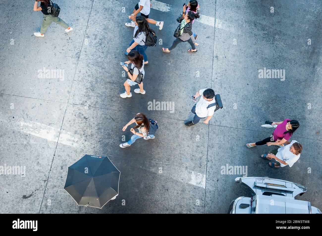 Aufnahmen von Fußgängern, die die Kreuzung neben der SM Clark Mall, der Angeles City Mall, den Philippinen überqueren. Stockfoto