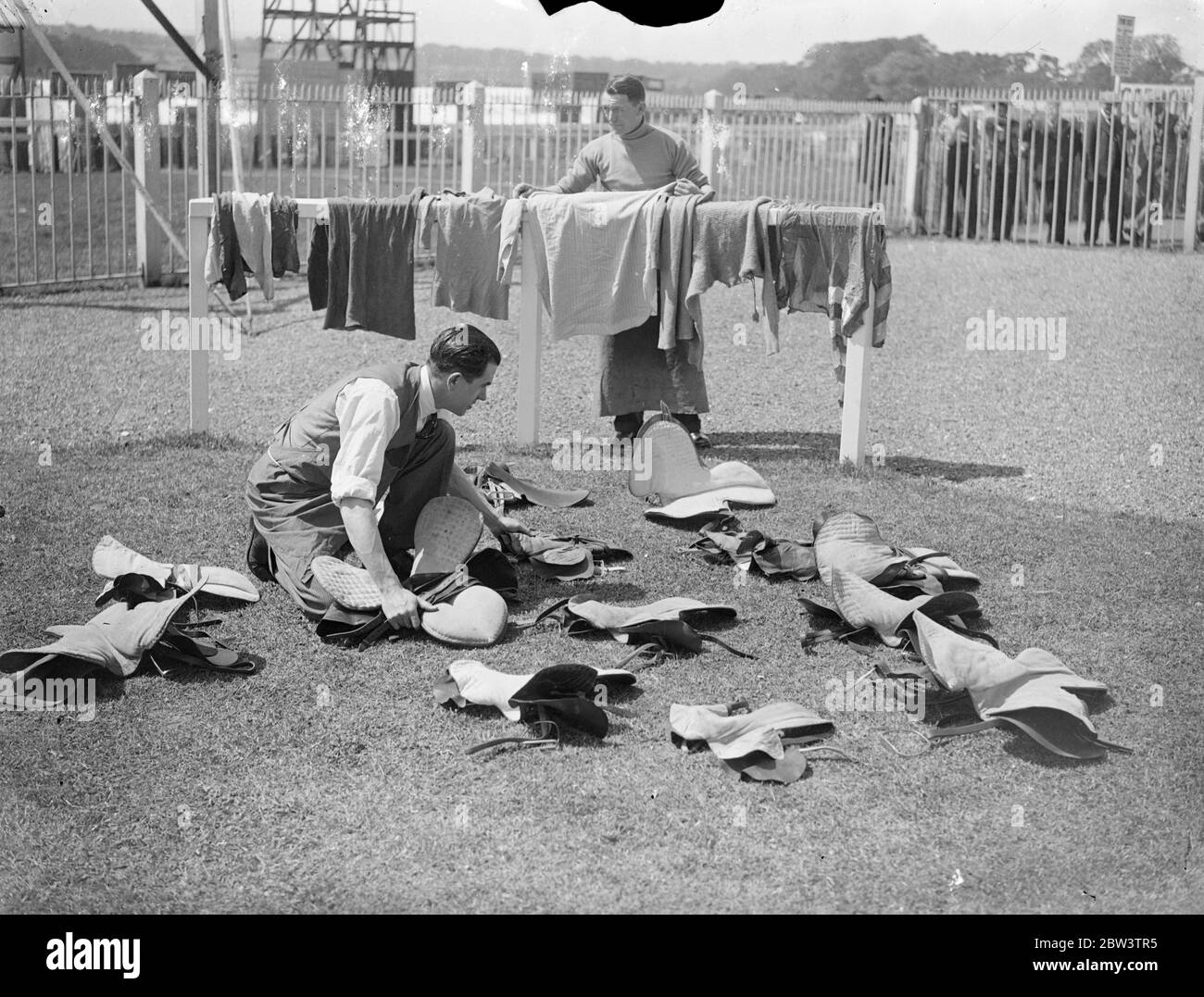Derby Vorbereitungen in Epsom. Epsom macht die letzten Vorbereitungen für das Derby am Mittwoch. Zusätzliche Polizei wird in die Stadt eingezogen, um mit Menschenmengen umzugehen und die Rennställe bereiten ihre Ausrüstung in Vorbereitung für den Tag. Foto zeigt Reinigung der Jockeys Stiefel und Sättel an einem Epsom Stables . 25 Mai 1936 Stockfoto