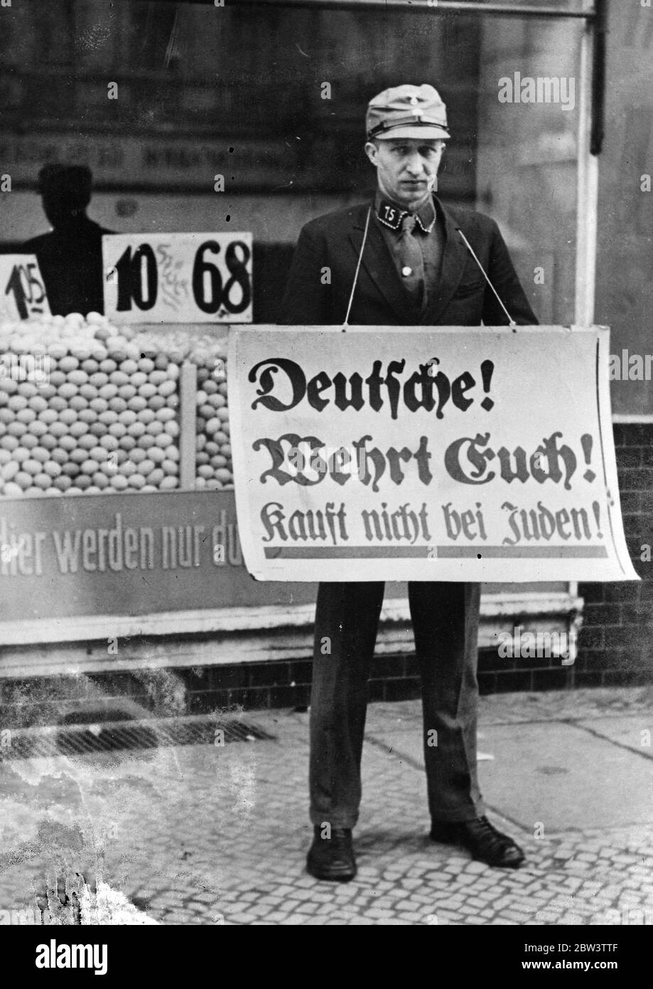 Ein deutscher Nazi-Unterstützer steht mit einem Sandwich-Board und ermutigt die Menschen, den Kauf in jüdischen Geschäften zu vermeiden. September 1935 Stockfoto